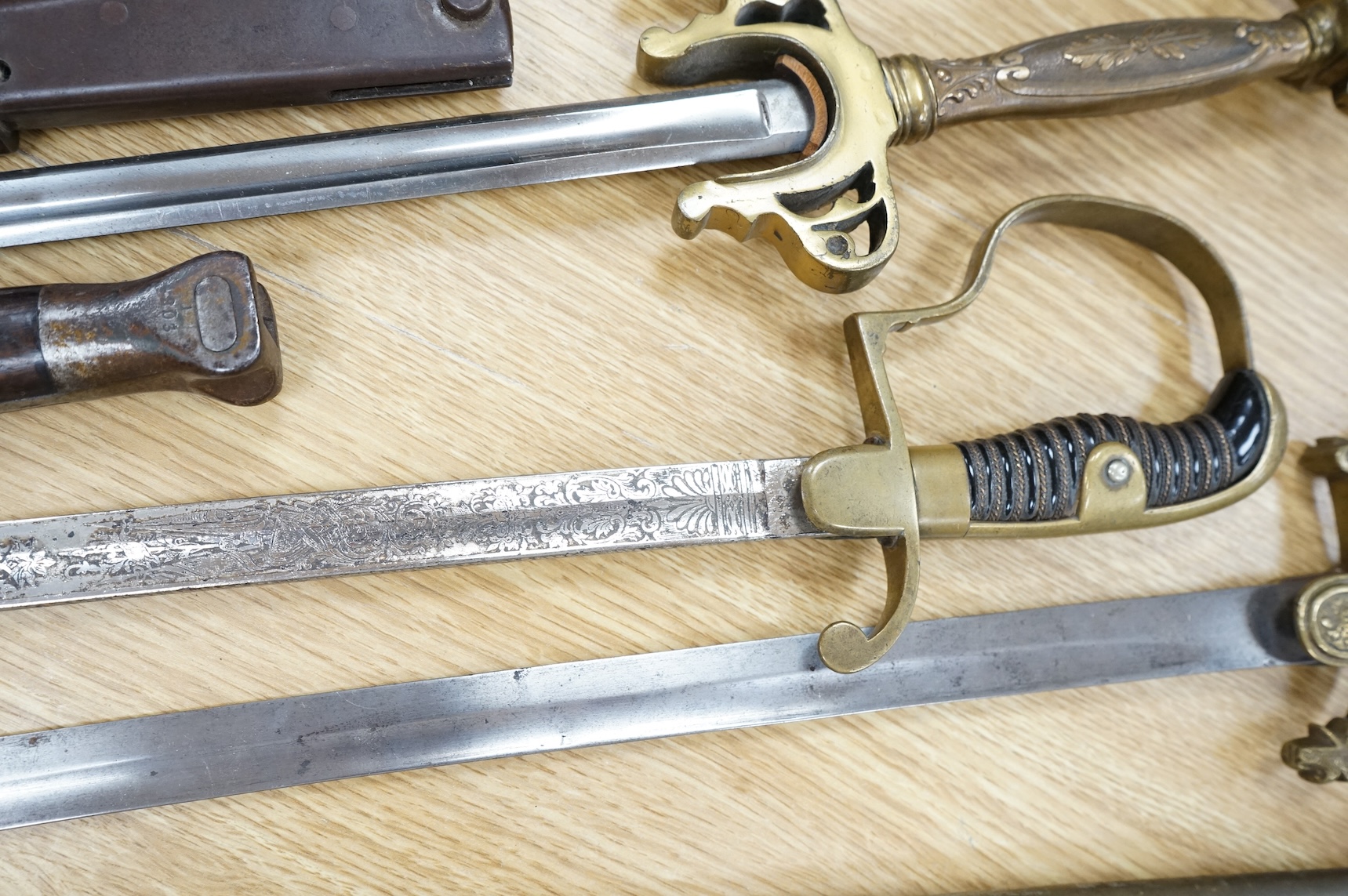 An Imperial German presentation infantry officer’s sword dated 1919/20, another similar with plain blade and brass stirrup hilt, another similar, plain in steel scabbard, a Wilkinson masonic sword probably circa 1950, a